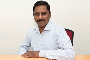 Technical Engineer Bharathi Kumar sitting at a desk