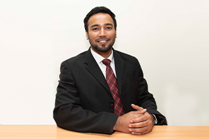 Sales Account Manager Mathews Cherian sitting at a table